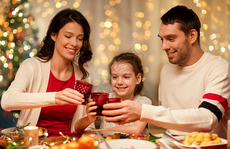节日,家庭庆祝快乐的母亲,父亲小女儿家里品尝诞晚餐幸福的家庭家里吃诞晚餐图片