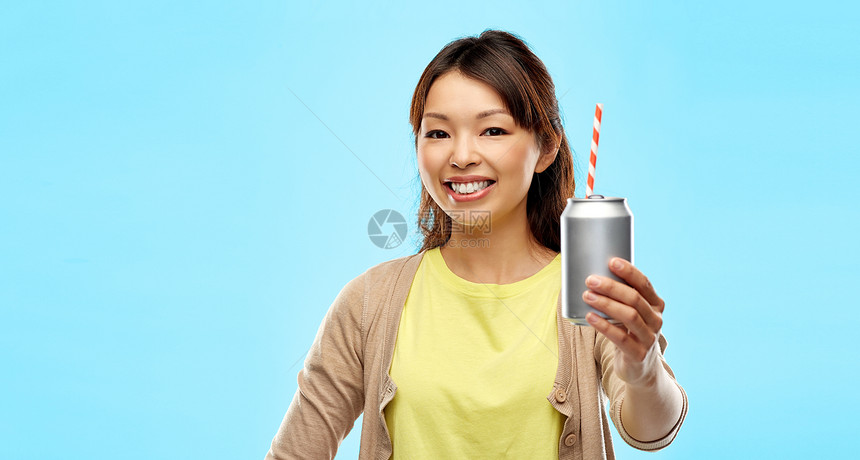 饮料人们的快乐的轻亚洲妇女喝苏打水罐头与纸吸管蓝色背景快乐的亚洲女人着可以用吸管喝酒图片