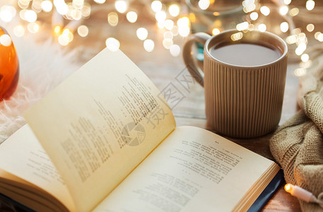 热灯潮湿舒适的家庭书杯咖啡热巧克力桌子上桌子上书杯咖啡热巧克力背景
