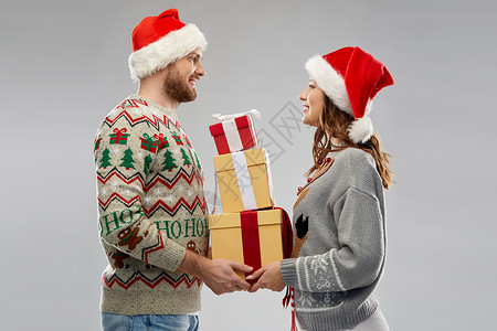 幸福的夫妇戴着诞帽带着礼物图片