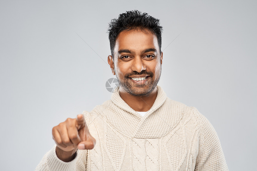 微笑的印度男人指着相机图片