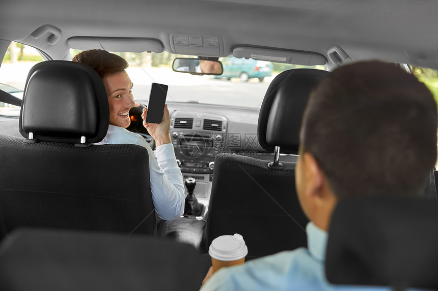 交通,出租车技术微笑汽车司机向男乘客展示智能手机汽车司机向男乘客展示智能手机图片
