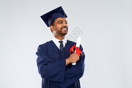 教育,毕业人的快乐微笑的印度男研究生砂浆板学士学位礼服与文凭灰色背景文凭的迫击炮董事会男研究生学术的高清图片素材