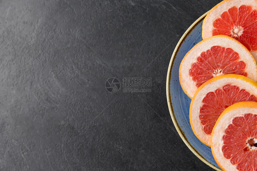 食物,水果健康的饮食新鲜多汁的切片葡萄柚板岩背景上的盘子把新鲜多汁的葡萄柚放盘子里图片