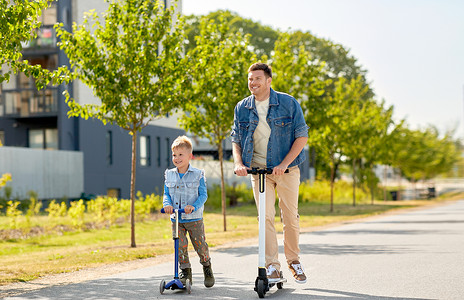 家庭,休闲父亲的快乐的父亲小儿子骑滑板车城市父亲小儿子城里骑滑板车图片
