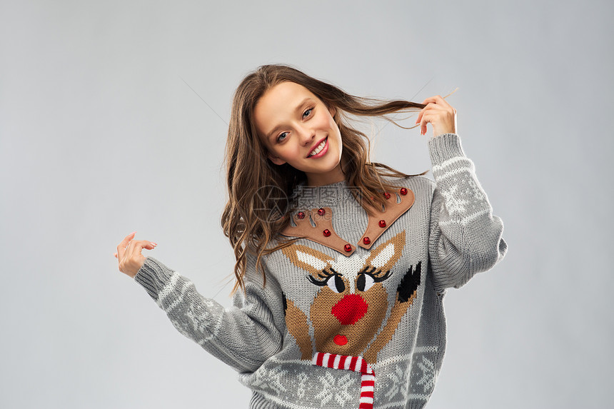 诞节,人节日的快乐的轻女人穿着毛衣与驯鹿图案穿着带驯鹿图案的诞毛衣的女人图片