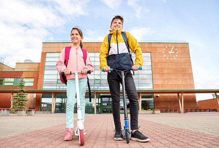 教育,童人的快乐的学校孩子与背包滑板车户外带背包滑板车的快乐学校孩子图片
