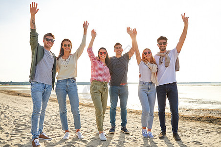 友谊休闲人的群快乐的朋友夏天的海滩上挥手快乐的朋友夏天海滩上挥手背景图片