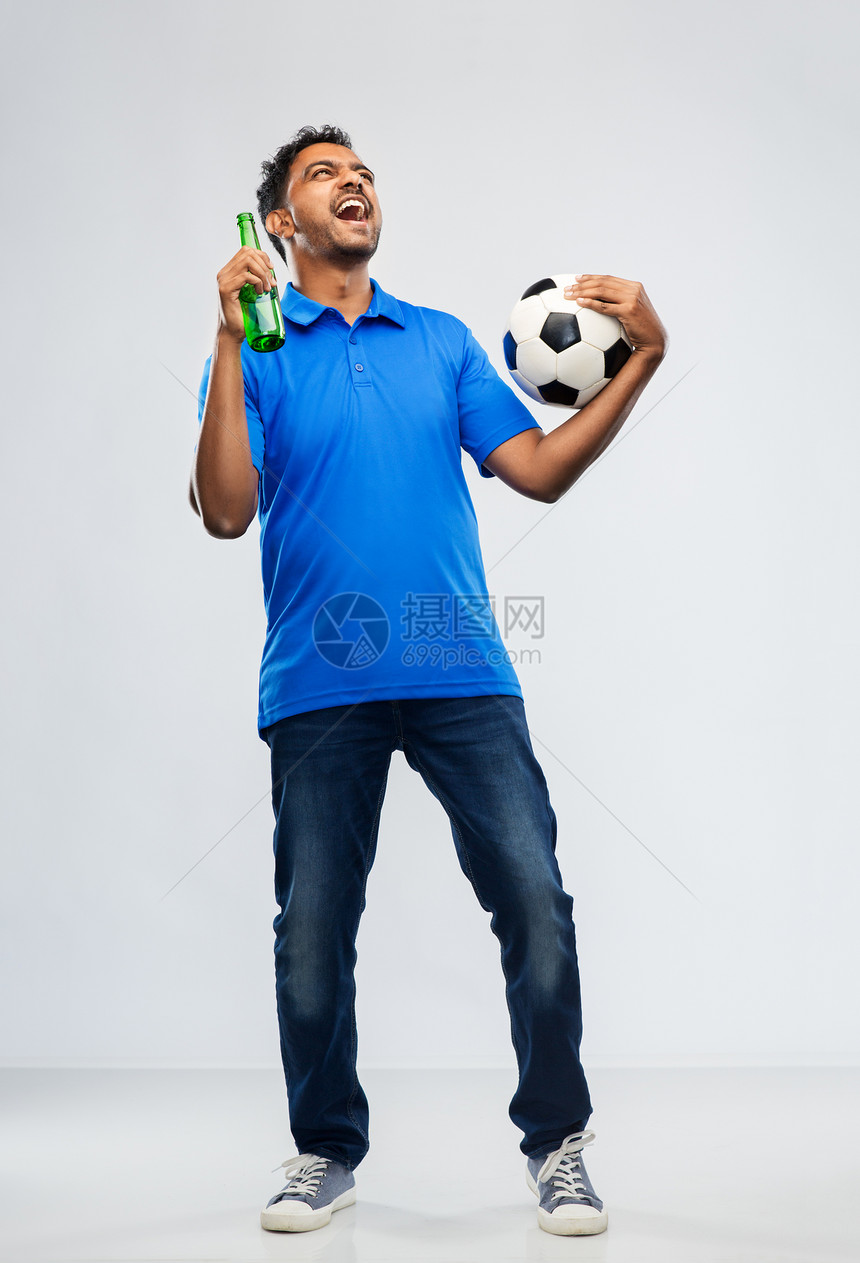 运动,休闲游戏成功快乐的印度男子足球迷与足球啤酒瓶庆祝胜利的灰色背景足球迷用足球庆祝胜利图片