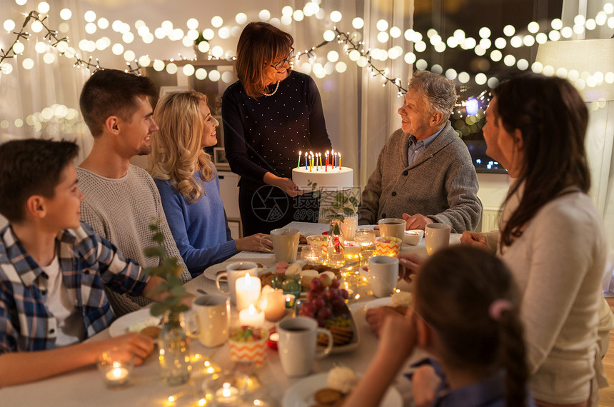晚餐派庆祝快乐的家庭与蛋糕庆祝祖父的生日家里幸福的家庭家里举行生日聚会图片