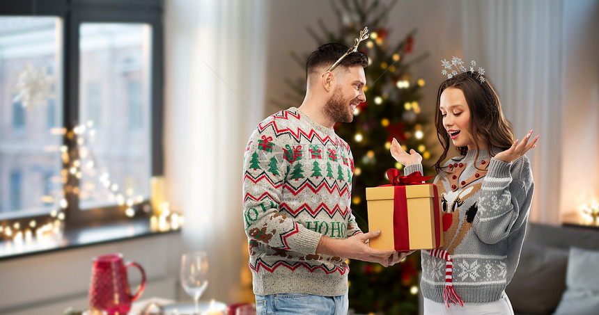 人节日的幸福夫妇的肖像与诞礼物毛衣派诞毛衣礼品盒的幸福夫妇图片