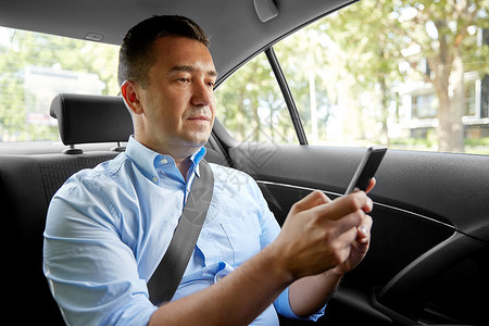 运输商业通信出租车后座用智能手机的男乘客商人乘客商人汽车中用智能手机图片