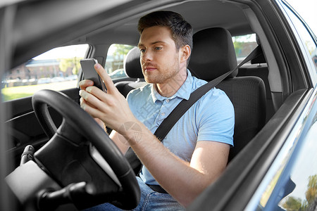 运输,车辆技术微笑的人司机驾驶汽车用智能手机开车用智能手机的人背景图片