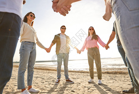 友谊,休闲人的群快乐的朋友夏天的海滩上牵手快乐的朋友夏天的海滩上牵手图片