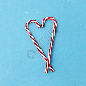 诞节寒假的糖果甘蔗装饰形状的心蓝色背景糖果手杖装饰的形状的心背景图片
