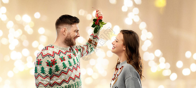 诞节,人们节日传统的幸福的夫妇毛衣与槲寄生节日的灯光背景诞快乐的槲寄生图片