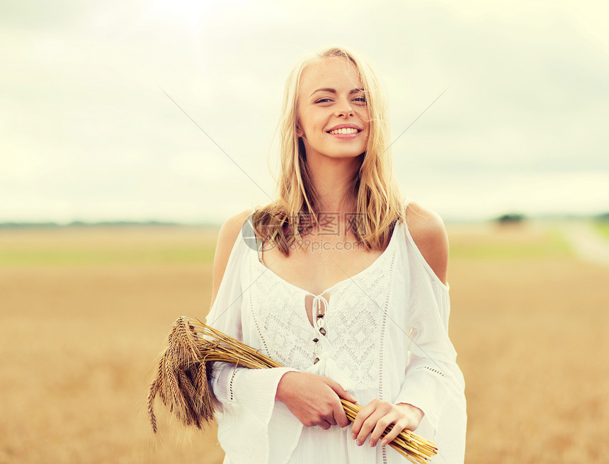 乡村,自然,暑假,假期人们的微笑的轻女人穿着白色的衣服,小穗走谷物地里快乐的轻女人谷物地里长着小穗图片