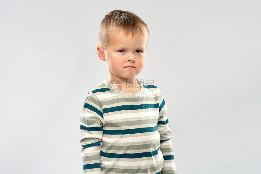 童人的悲伤的小男孩穿条纹衬衫灰色背景的肖像穿条纹衬衫的悲伤小男孩的肖像图片