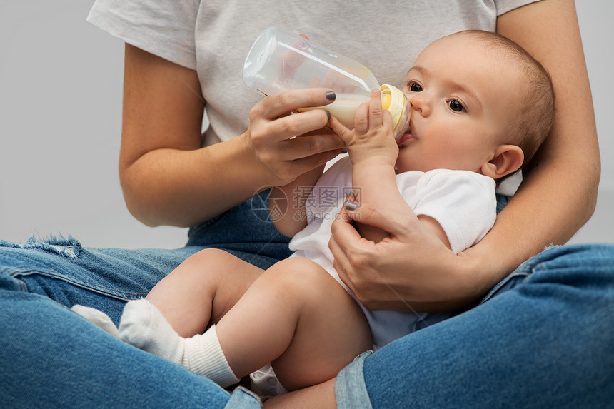 家庭,婴儿人的密切母亲喂养婴儿的牛奶配方瓶子用牛奶配方母亲喂养婴儿图片
