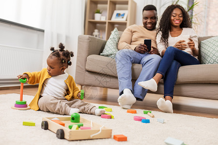 童人的小非洲裔美国女婴玩玩具块父母用智能手机家非洲女婴家玩玩具积木图片
