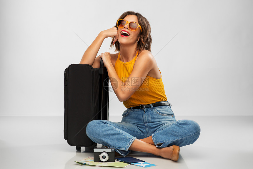 旅行,旅游度假的快乐的笑轻妇女芥末黄色顶部与机票,相机,随身袋灰色背景带旅行袋机票相机的女人图片