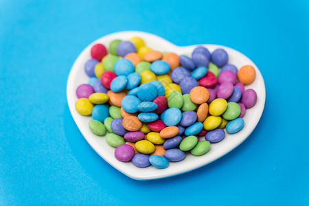 五彩心形光效糖果,糖果情人节糖果滴心形盘子上的上心形盘子上的糖果背景
