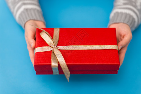 节日,礼物问候手小诞红色礼品盒与金结蓝色背景双手捧着红色诞礼盒图片