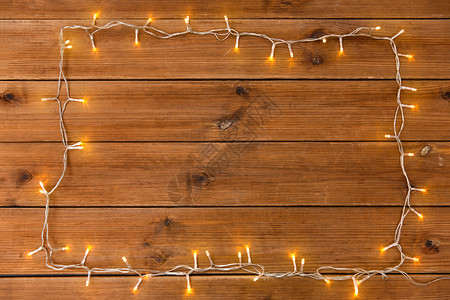 诞节,假日照明木制背景上的电动花环灯框架木制背景上的花环灯框架背景图片