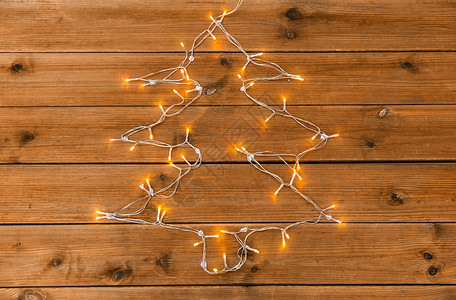 圣诞树灯串假日照明电动花环灯串形状的诞树木制背景花环灯串形状为诞树背景