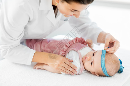 医学,医疗儿科女儿科医生与测量磁带测量女婴病人诊所医院的头儿科医生诊所测量婴儿的头部背景图片