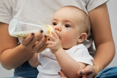 家庭,婴儿人的密切母亲喂养婴儿的牛奶配方瓶子用牛奶配方母亲喂养婴儿背景图片