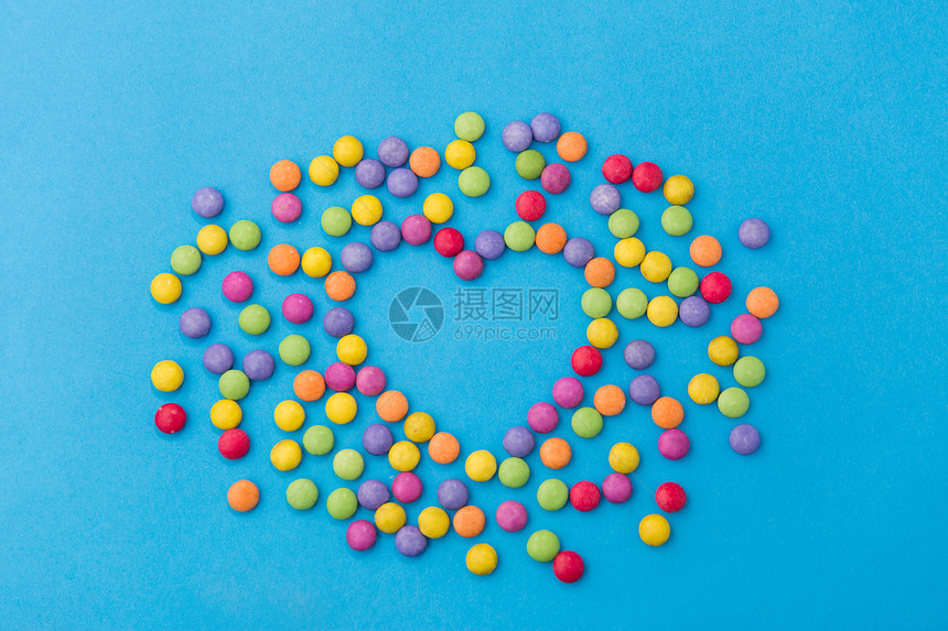 糖果,糖果情人节的明亮的五彩糖果滴形状的心脏蓝色背景糖果滴蓝色背景上的心脏形状图片