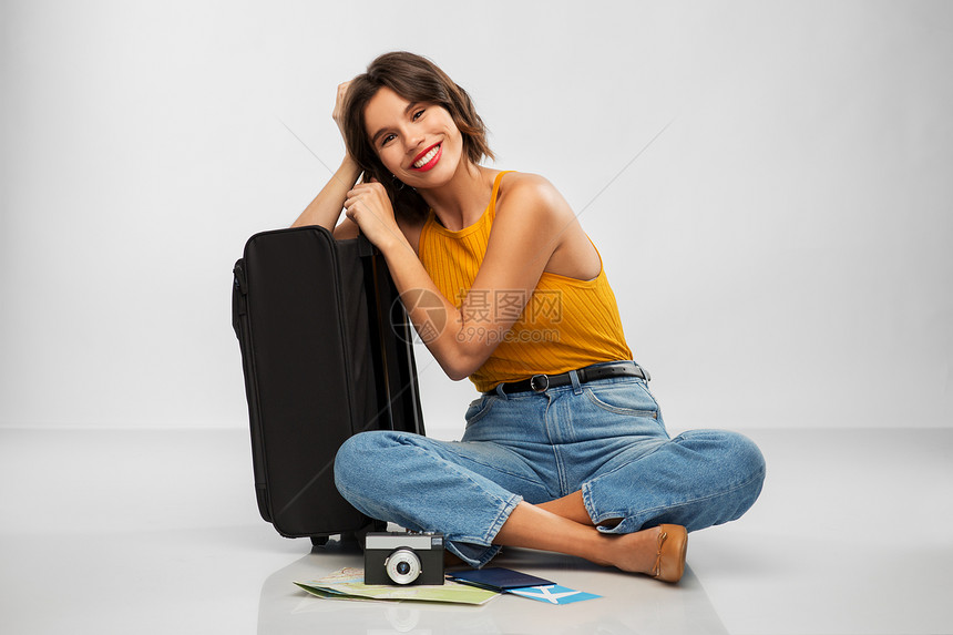 旅行,旅游度假的快乐的微笑轻妇女芥末黄色顶部与机票,相机,随身袋灰色背景带旅行袋机票相机的女人图片
