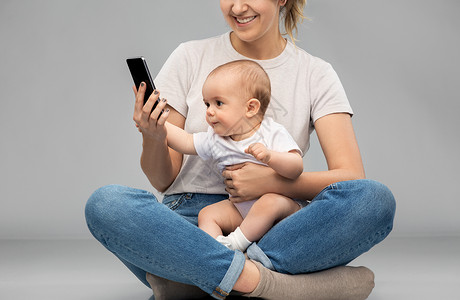 家庭技术母母亲婴儿看智能手机母亲婴儿看着智能手机图片