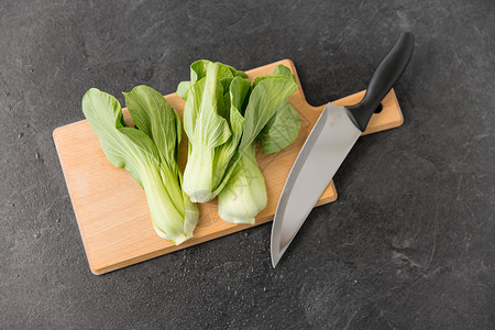 蔬菜,食物烹饪Bokchoy大白菜菜刀木制切割板上的石板石背景白菜切板上的刀背景图片