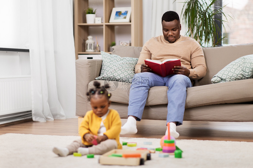 家庭,技术人的快乐的非裔美国人父亲读书婴儿女儿家里玩玩具积木快乐的父亲家里平板电脑婴儿图片