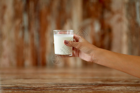 食物,饮食乳制品的近距离的女手着杯牛奶特写女手着杯牛奶背景图片