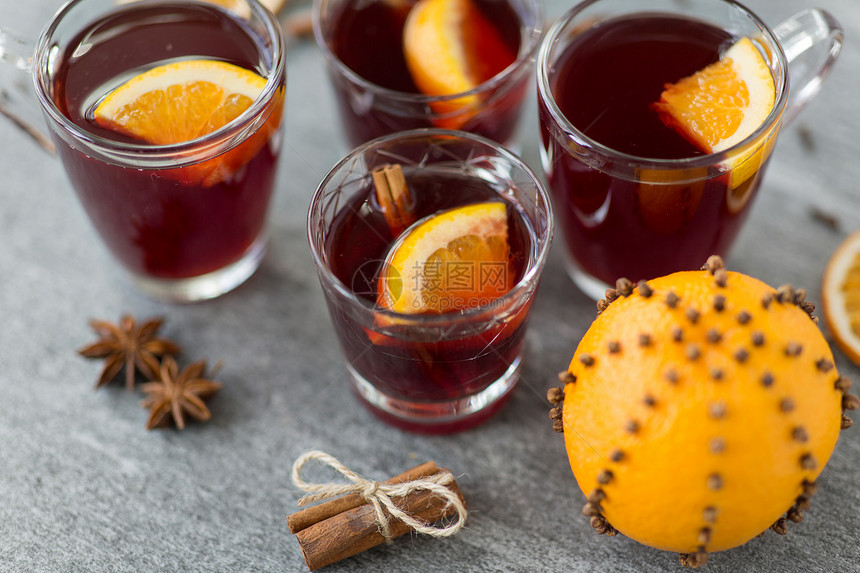 诞节季节饮料杯热覆盖葡萄酒与橙色肉桂灰色背景杯带橙色肉桂的覆盖葡萄酒图片