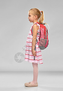 童,教育人的快乐的学生女孩,书包灰色背景带书包的快乐学生女孩图片