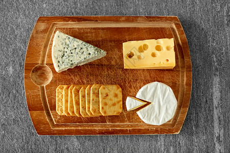 食物饮食同种类的奶酪咸饼干木制切割板上木板上同的奶酪饼干图片