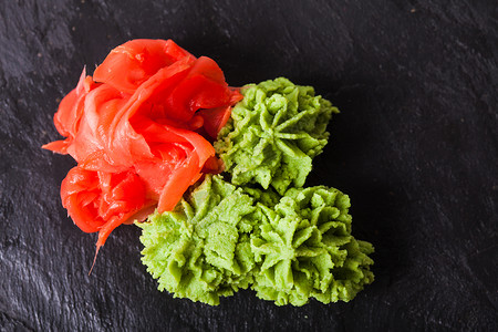 酱红色由日本辣根姜粉腌片制成的芥末绿色糊状物芥末生姜寿司的传统开胃菜背景