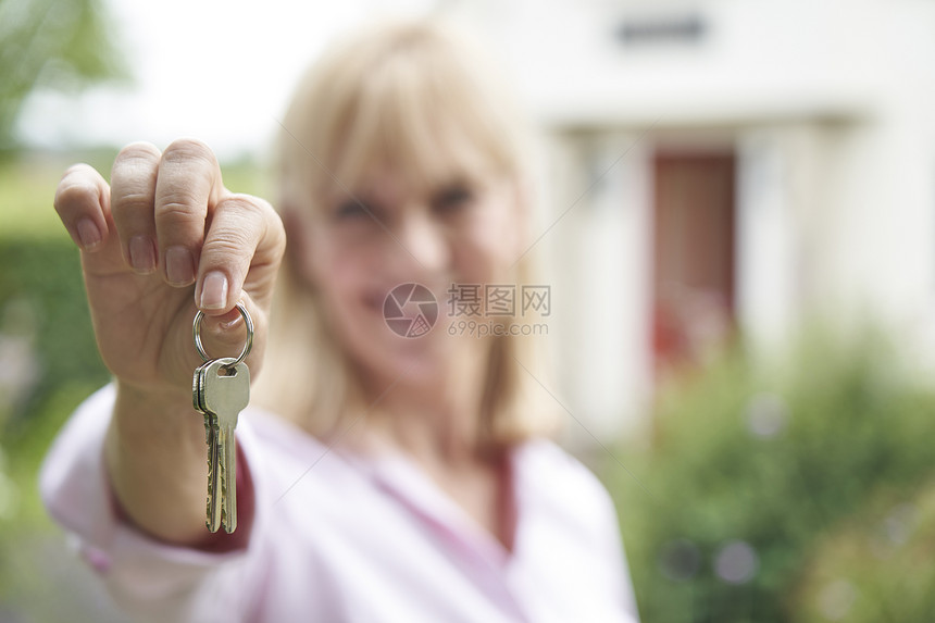 成熟女人站花园里的肖像,农村的梦想家园前着钥匙图片