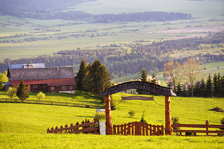 农场大门乡村绿泉景观山上的房子村庄拱门大门的栅栏波兰的Malopolska地区背景