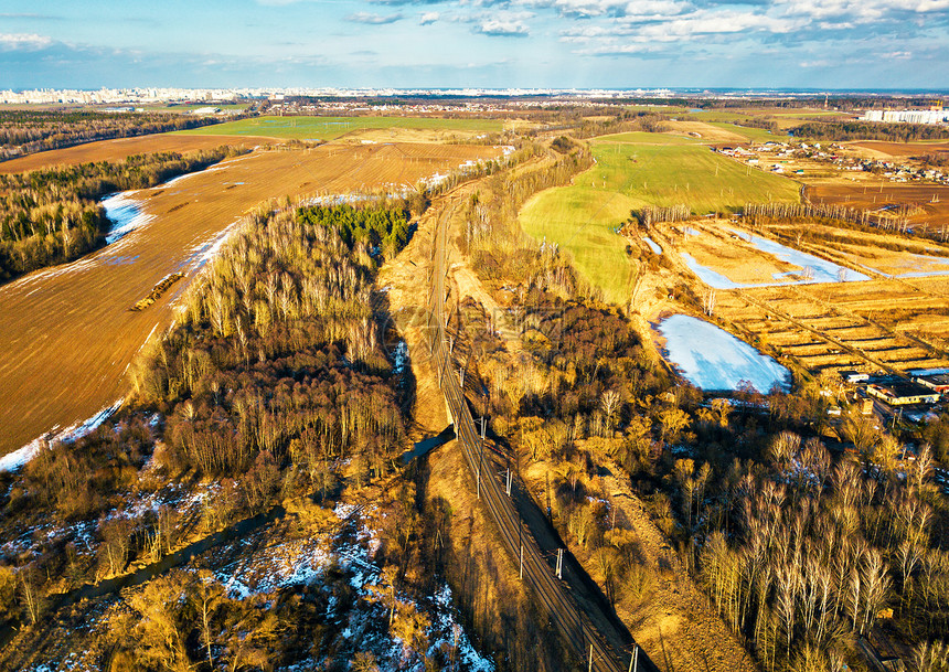 春季乡村空中景观三月农田上的春天融化的雪铁路背景上经过明斯克市冬季作物耕地白俄罗斯图片