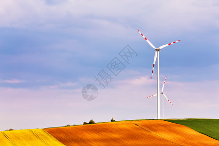 下多伦多夫春天阳光明媚,绿色的田野里风力发电机生态动力风力涡轮机公园发电山顶上的狩猎箱下奥地利,靠近珀斯多夫背景