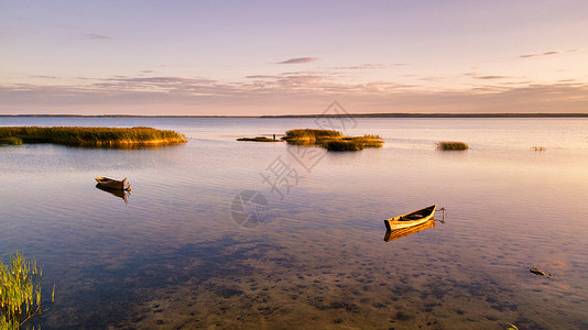 阳光明媚的夏日,干燥的湖上,帆船的景色,日落的光线浅滩水上的寄宿点风景如画图片