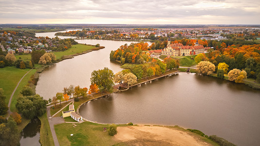 纳斯维兹中世纪城堡的秋季鸟瞰尼亚斯维兹古镇五颜六色的枫树公园白俄罗斯明斯克地区背景