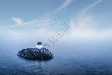 水晶球个朦胧的海景岩石上,平静的蓝色水域背景图片