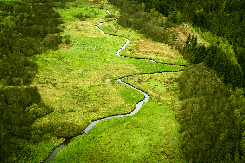 弯曲的河流穿过个绿色的区域,看田野森林图片