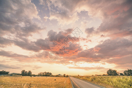 乡村日落,条沥青路,穿过乡村景观,个农场干燥的田野图片